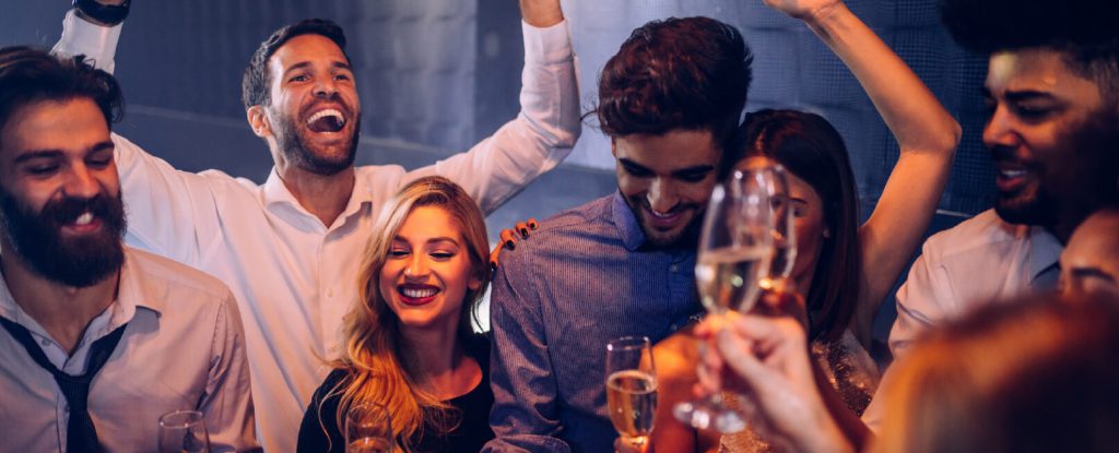 Friends laughing and posing for photos in a club setting